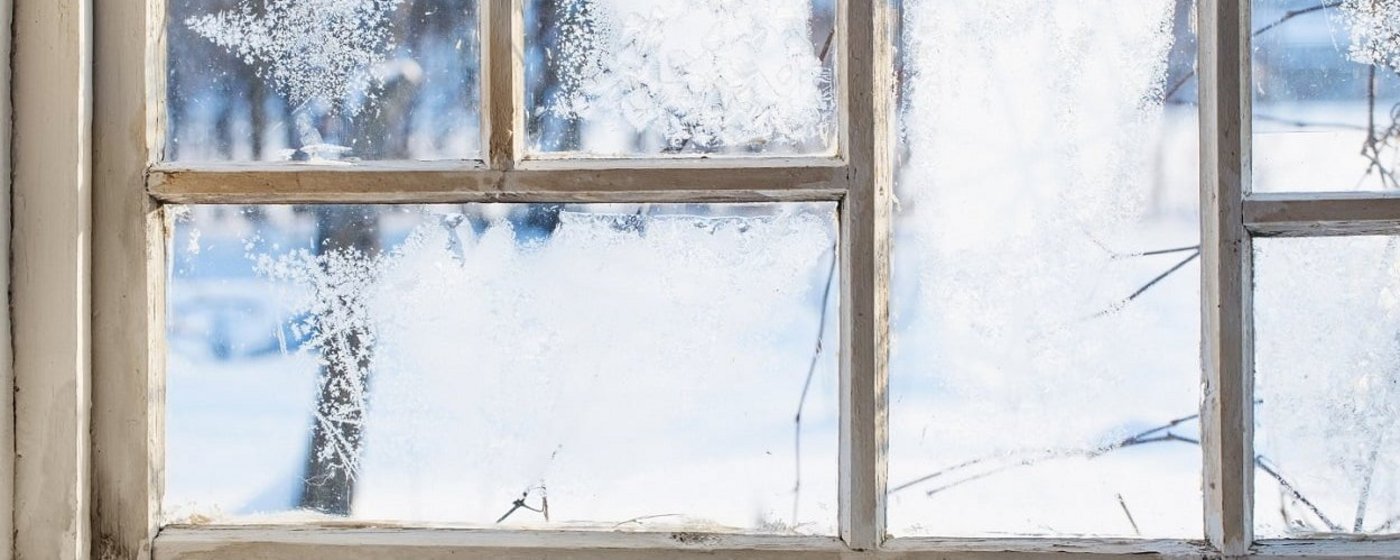 Holzfenster mit Frost an der Scheibe